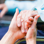 Two hands clasped together, symbolizing care and support