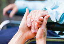 Two hands clasped together, symbolizing care and support