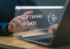User interacting with a laptop displaying a software update progress