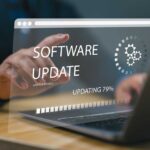 User interacting with a laptop displaying a software update progress
