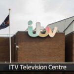 Exterior view of the ITV Television Centre with a flag and signage