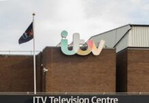 Exterior view of the ITV Television Centre with a flag and signage