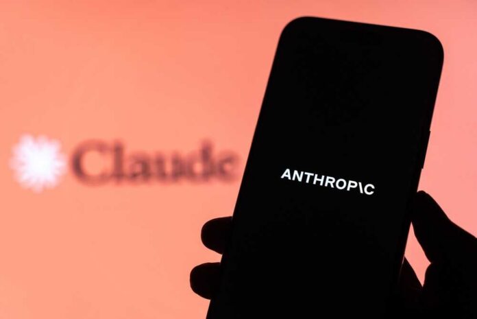 A hand holding a smartphone displaying the word 'ANTHROPIC' against a blurred background
