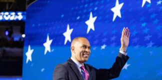 Person waving in front of a starry blue background