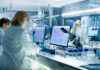 Scientists working at computers and microscopes in a modern laboratory
