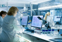 Scientists working at computers and microscopes in a modern laboratory