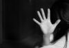 A hand raised in a stopping gesture against a blurred background