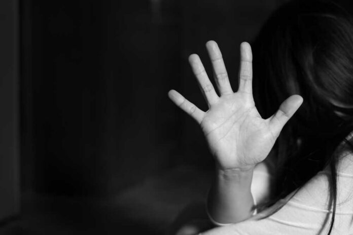 A hand raised in a stopping gesture against a blurred background