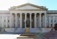 A historical statue in front of a large government building with columns