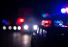 Close-up of a police car model with flashing lights in a dark setting