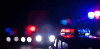 Close-up of a police car model with flashing lights in a dark setting
