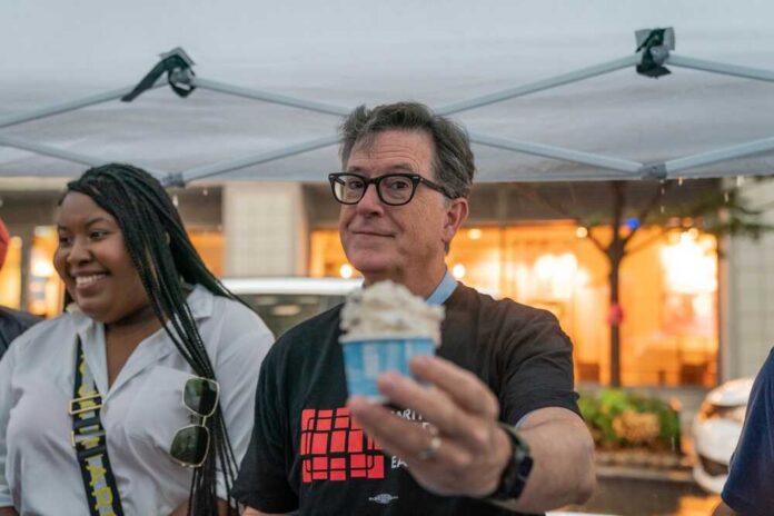 man holding a cup of ice cream under a canopy