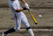 A baseball player swinging a bat at a pitch