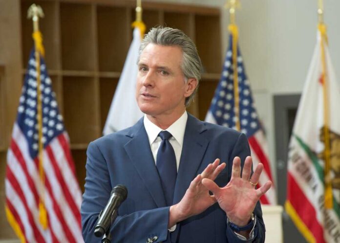 A government official speaking at a podium with American flags in the background