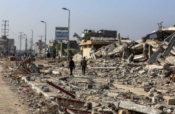 Two individuals walking through a devastated urban area filled with rubble