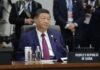 A leader seated at a conference table during an international summit