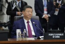 A leader seated at a conference table during an international summit