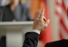 Audience member raising hand during a presentation