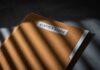A brown file folder with the name 'EPSTEIN' on it, partially illuminated by light and casting shadows.