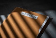 A brown file folder with the name 'EPSTEIN' on it, partially illuminated by light and casting shadows.