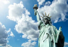 Statue of Liberty under a cloudy sky.