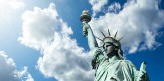 Statue of Liberty under a cloudy sky.