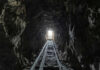 Dark tunnel leading to bright exit with tracks