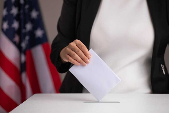 Person casting a ballot into a voting box