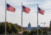 Three American flags waving in front of the Capitol building