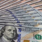 A close-up view of a stack of hundred dollar bills arranged neatly
