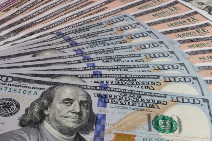 A close-up view of a stack of hundred dollar bills arranged neatly