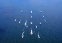 Aerial view of multiple naval ships operating in the ocean