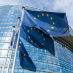 European Union flags outside modern glass building