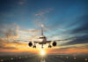 Airplane landing on runway during sunset sky