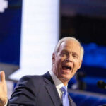 Man speaking passionately at a podium on stage