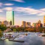 City skyline with river and boats at sunset