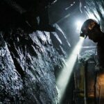 miner with headlamp working in a dark tunnel