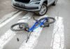 Bicycle lying on crosswalk in front of a car