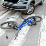 Bicycle lying on crosswalk in front of a car