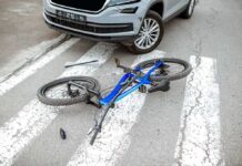 Bicycle lying on crosswalk in front of a car