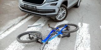 Bicycle lying on crosswalk in front of a car