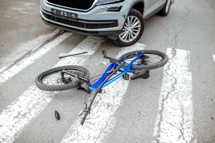Bicycle lying on crosswalk in front of a car