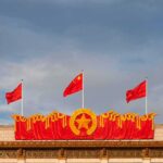 Chinese flags atop a decorated building facade