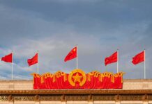 Chinese flags atop a decorated building facade