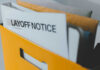 A yellow folder containing a layoff notice and other documents