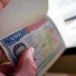 Hand holding a passport with a visa page