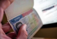 Hand holding a passport with a visa page
