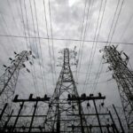 High-voltage transmission towers and power lines against a cloudy sky