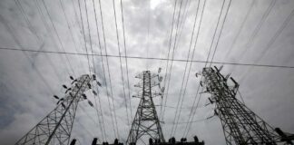 High-voltage transmission towers and power lines against a cloudy sky