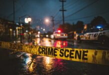 Police cars at a crime scene with caution tape in the foreground